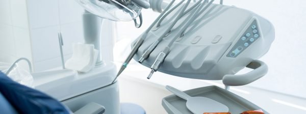 Clean professional design of working machines of dentist placed near client seat.
